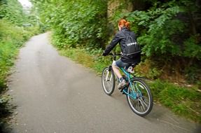 girl is cycling on a rural road