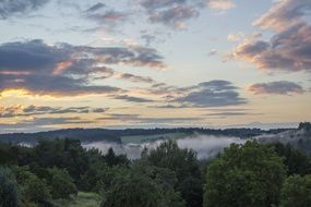 the evening sky and fog over the forest