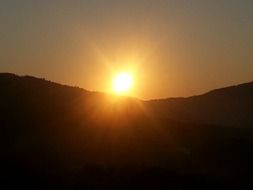 sunset afterglow over dark mountain