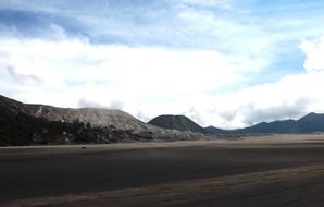 bromo mountains in scenic dark desert landscape, indonesia, east java