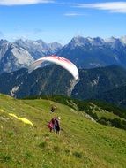 skydiver landed on a green hillside
