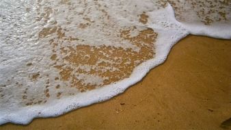 ocean wave on a sandy beach close up