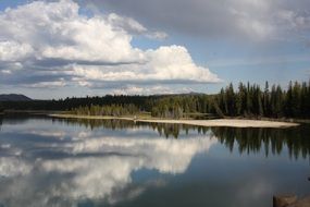 reflection of trees and clouds in the lake