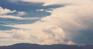 white fluffy clouds over the mountains