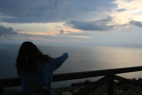 girl looking to the mediterranean sea at the sunset