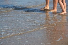 two pair of feet on pebble beach