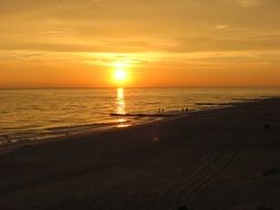 Colorful sunset among the clouds over Madeira beach at dusk