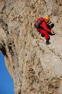 photo of climber in a red suit on a rock