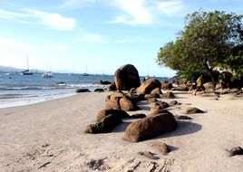 sandy beach with large boulders