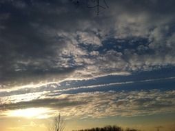 sun rays and clouds in the sky at dusk