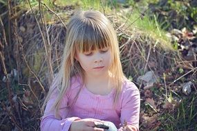 Photo of a girl with blond hair on nature