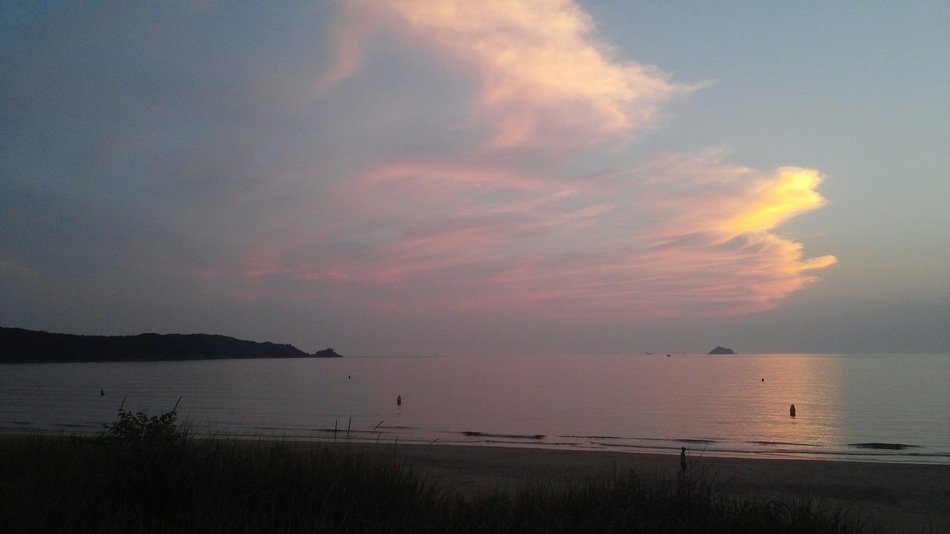 glow of sunset in the clouds above the water