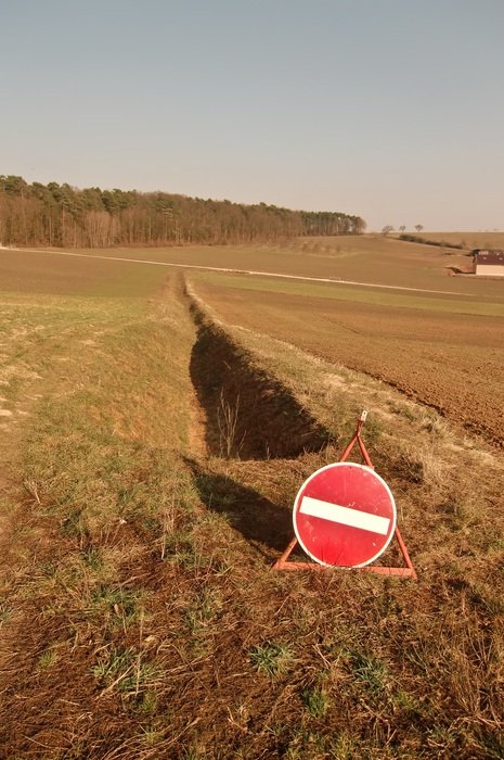 stop street sign at field before ditch