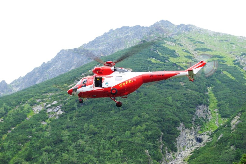 landscape with red and white helikoter in a flight over the mountains
