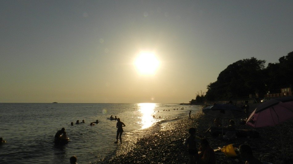 People by the sea during beautiful and colorful sunset on the coast