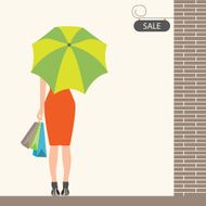 Back of woman holding shopping bags and umbrella