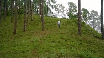 man running from a green mountain