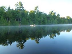 reflection of a green forest in a blue lake in Canada