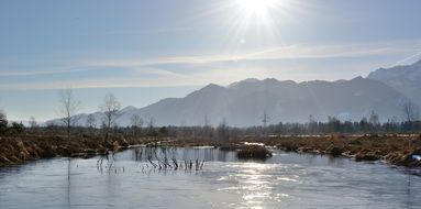 photo of sun rays over a lake at dawn in Chiemgau