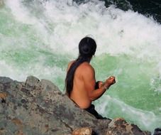 indian person at the waterfall