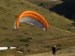 paraglider on a background of green mountains
