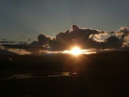 sun between clouds at sunset