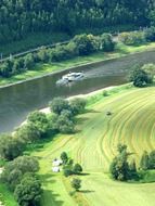 ship sailing on the river and green field top view