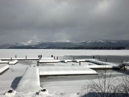 pier covered with snow and frozen lake