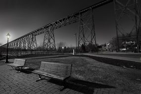 wooden benches near a street lamp in the dark