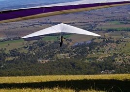 man on a paraglider in the sky over the mountains