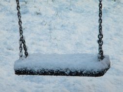 closeup photo of snow on free chain swing