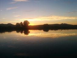 calm lake in the rays of the setting sun