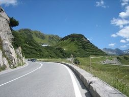 fenced road away in alpine landscape