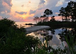 scenic sunset mirroring on water at coast