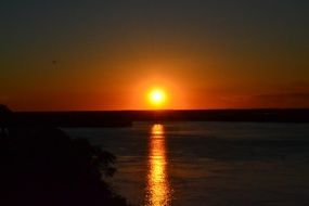 bright orange sky over the river during sunset