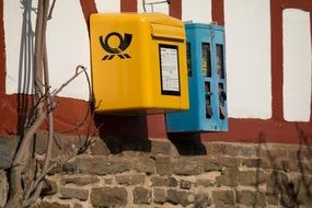 yellow and blue mailboxes on wall