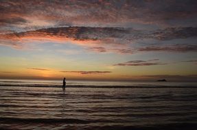 man walking on the beach at sunset