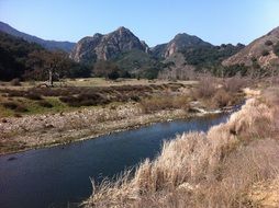 narrow shallow river in highlands on landscape