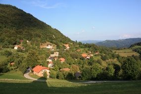 remote view of a village among a forest on a hill in Slovenia