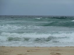 foamed waves splashing on sand beach