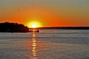 orange sun reflected in water in sweden
