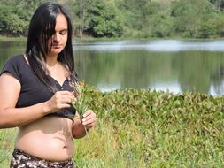 girl with a flower in her hand by the lake