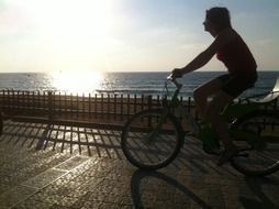 girl is riding a bike along the promenade