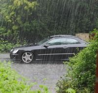 black auto on road in the rain