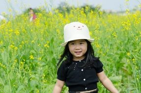 little girl with a hat in the flower field