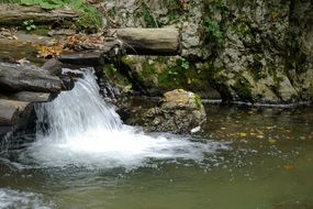 small waterfall in the middle of a wild river