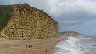 people on the shore of the west bay on a sunny day