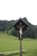 Cross with crucified Jesus on the side of the road