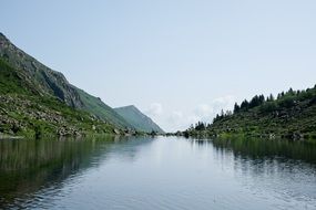 reflection of trees in a lake near the mountain