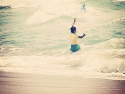 little fisherman in coastal waves